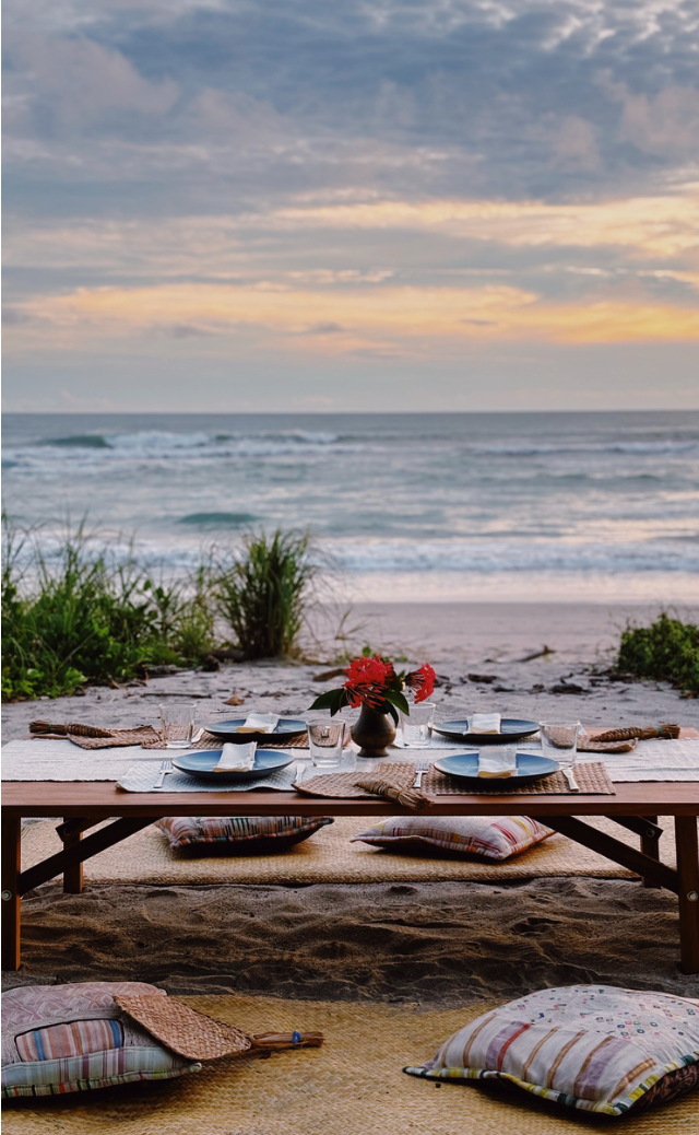 A table set on the sand at sunset