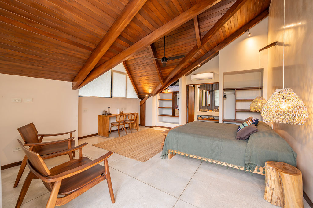Interior of the loft suite showing the exposed A-frame truss, desk and wardrobe wall
